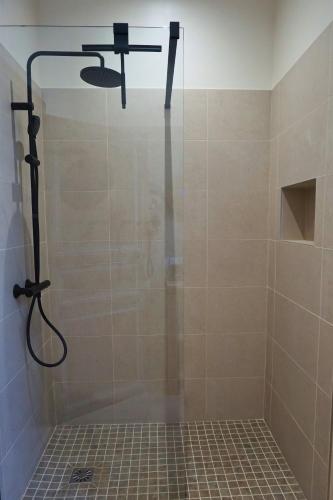 a shower with a shower head in a bathroom at Maison Constant - L'Erable in Autun