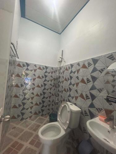 a bathroom with a toilet and a sink at Camiguin El Rio Dorado in Catarman