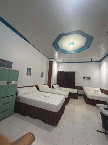 a bedroom with two beds and a blue ceiling at Camiguin El Rio Dorado in Catarman