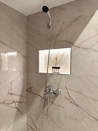 a shower with a shower head in a bathroom at Nikoletta in Katerini