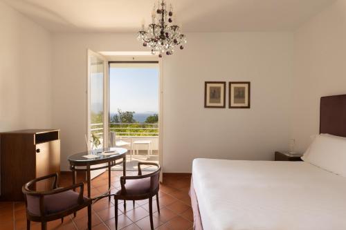 a bedroom with a bed and a table and chairs at Villa Oriana Relais in Sorrento