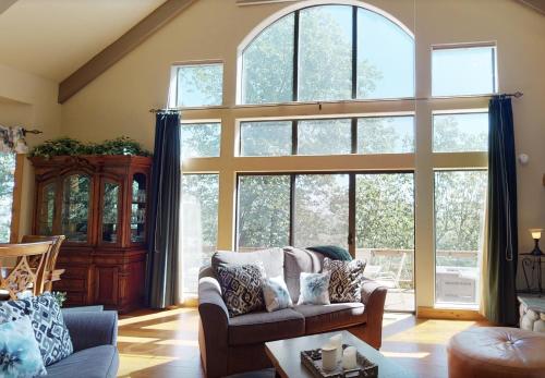 a living room with large windows and a couch at Emerald Oasis in Lake Arrowhead