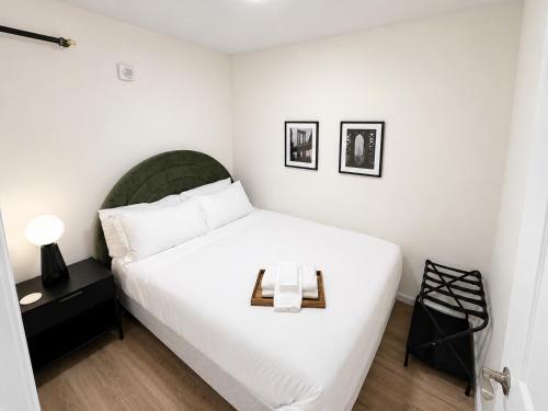 a bedroom with a white bed with a tray on it at The Brick & Beam 3rd Floor Apartment in St. Charles
