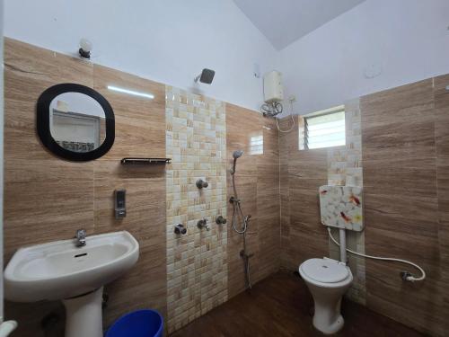 a bathroom with a sink and a toilet and a mirror at JBL Beach Resort Mandarmoni in Mandarmoni