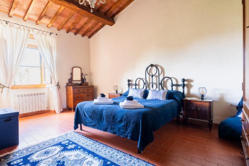a bedroom with a bed with a blue bedspread at CASA LORY Poggio Murella in Poggio Murella