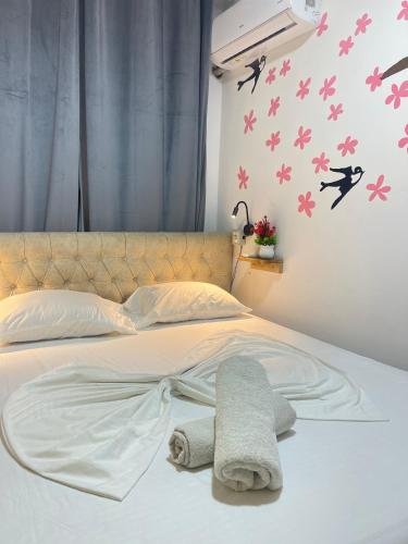 a bed with towels and birds on the wall at Vlora Backpackers Hostel & Bar LUNGOMARE in Vlorë