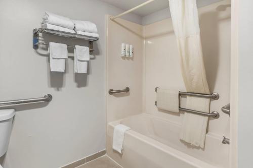 a bathroom with a tub and a shower with towels at Quality Inn Kinston Hwy 70 in Kinston