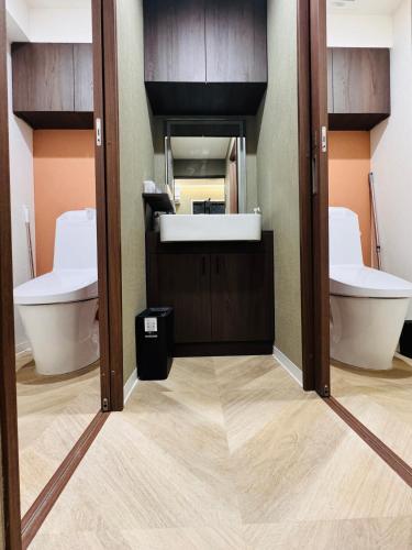 a bathroom with two toilets and a sink at Guest house雅 in Matsudo