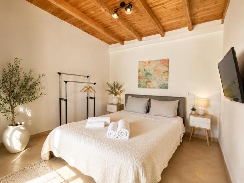 a bedroom with a large bed with towels on it at Blue Topaz cottage Mini pool Spa in Nafplio