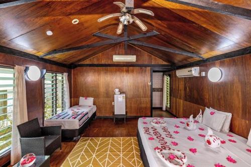 a room with two beds and a ceiling fan at Orator Hotel in Siusega