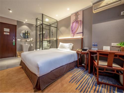 a bedroom with a bed and a desk and a bathroom at Uniton Hotel Shenzhen in Shenzhen