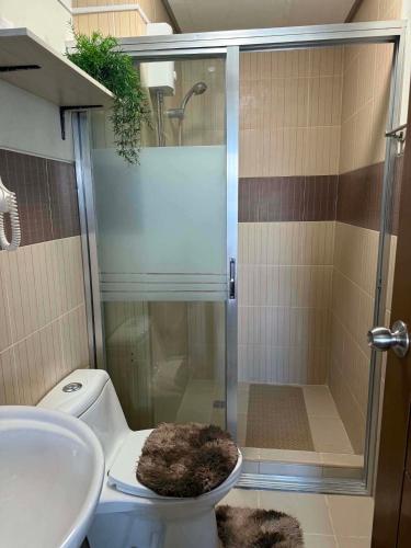 a bathroom with a shower and a toilet and a sink at Spacious Studio unit with Balcony and Seaview in Punta Engaño
