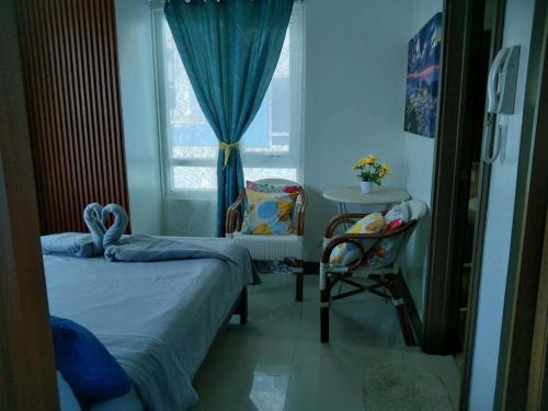 a bedroom with a bed and a chair and a window at Spacious Studio unit with Balcony and Seaview in Punta Engaño