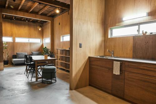 a kitchen with a sink and a table with chairs at Nem Kumano by WhyKumano in Nachikatsuura