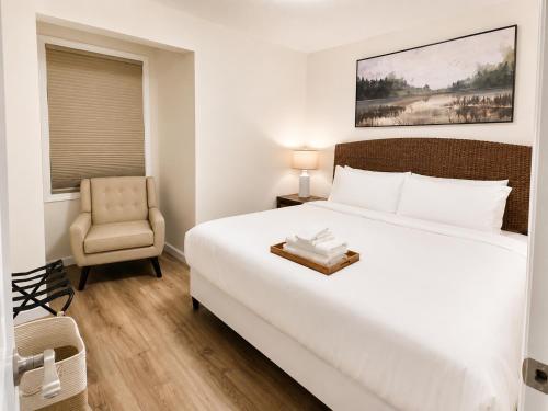 a bedroom with a large white bed and a chair at The Riverwood Retreat in St. Charles