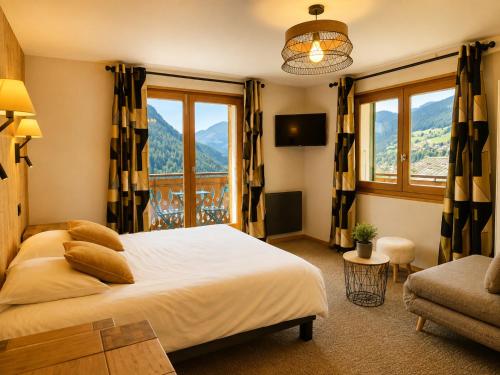 a bedroom with a bed and a large window at Hôtel Belalp in Châtel