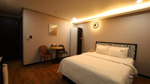 a hotel room with a bed and a table at 수원행궁 넘버25 in Suwon