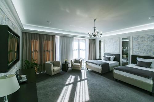 ein Hotelzimmer mit zwei Betten und einer Couch in der Unterkunft Bon Hotel in Dnipro