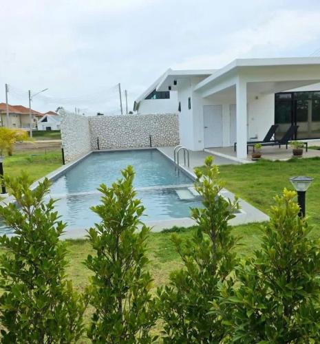 a swimming pool in the yard of a house at Indigo Garden Villa by Somjai in Ban Tha Fat