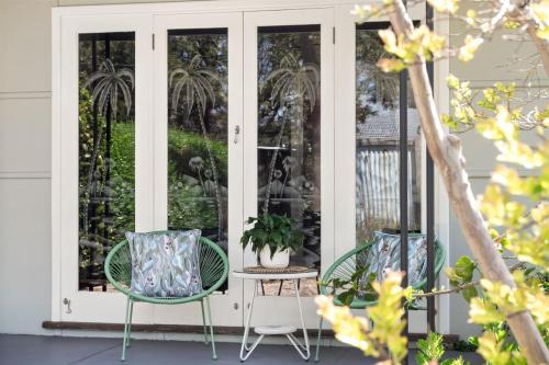 two chairs and a table on a front porch at Elva Garden Cottage - Dog Friendly - Town Central in Margaret River Town