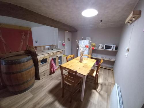 a kitchen with a wooden table and a wine barrel at Chambre bleue in La Roche-sur-Yon