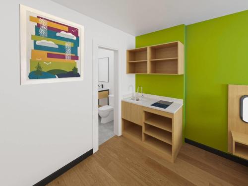 a green bathroom with a sink and a toilet at Park Inn by Radisson, Fort Dodge Downtown in Fort Dodge