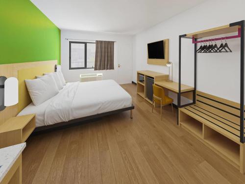 a bedroom with a bed and a desk with a computer at Park Inn by Radisson, Fort Dodge Downtown in Fort Dodge