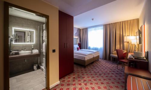 a hotel room with a bed and a bathroom at Hotel Postgalerie Speyer in Speyer