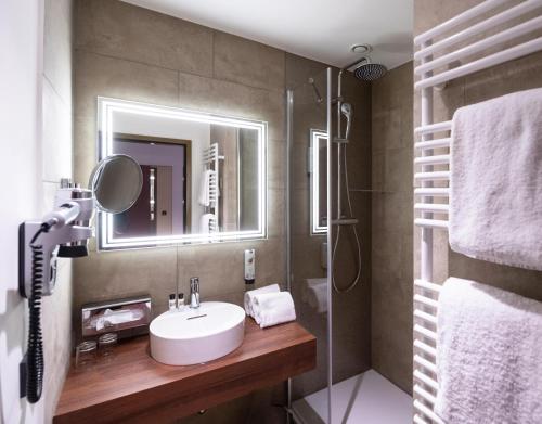a bathroom with a sink and a shower at Hotel Postgalerie Speyer in Speyer