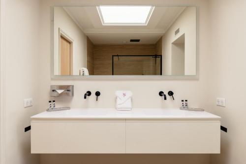 a bathroom with a white sink and a mirror at Résidence Carlton - Rénovée avec Piscine in Beaulieu-sur-Mer