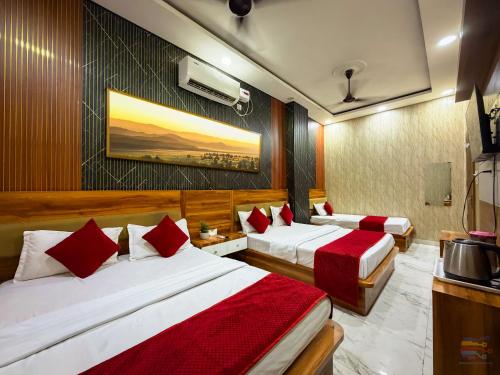 a hotel room with two beds with red pillows at Hotel Banke Bihari Dham in Vrindāvan
