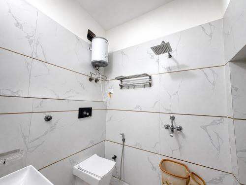 a white bathroom with a toilet and a sink at Hotel Banke Bihari Dham in Vrindāvan