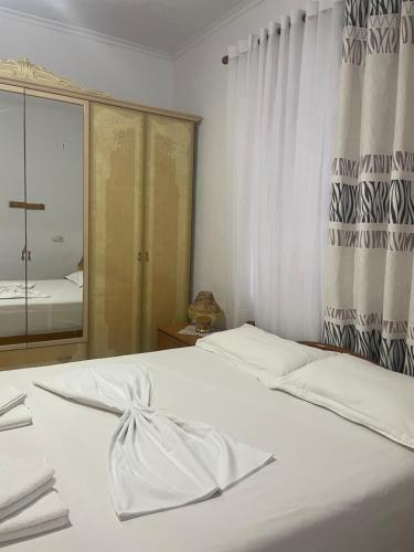 a white bed in a bedroom with a window at Villa Victoria in Gjirokastër
