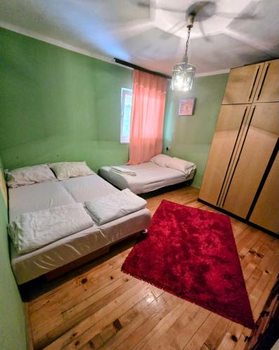 a bedroom with two beds and a red rug at MiR in Londža