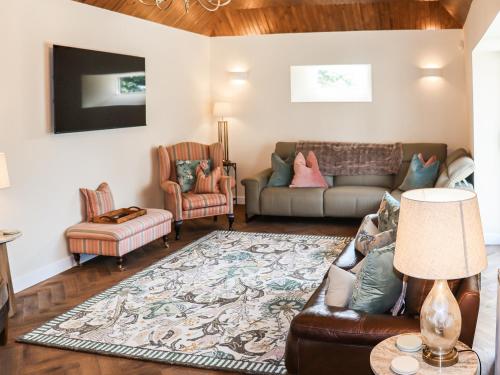 a living room with a couch and two chairs at The Coach House in Auchtermuchty