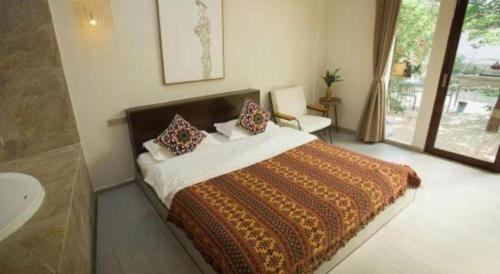 a bedroom with a large bed and a bathroom at Dali Five Elements Hostel in Dali Ancient Town