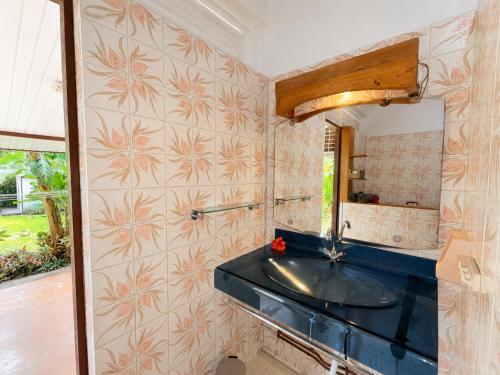 a bathroom with a sink and a mirror at PK 35 in Apomaoro