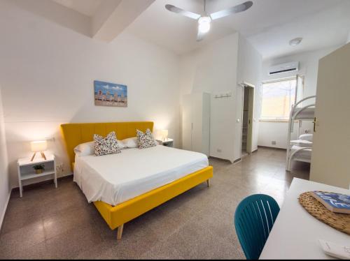 a bedroom with a bed with a yellow headboard at Marescià Siculiana Marina in Siculiana