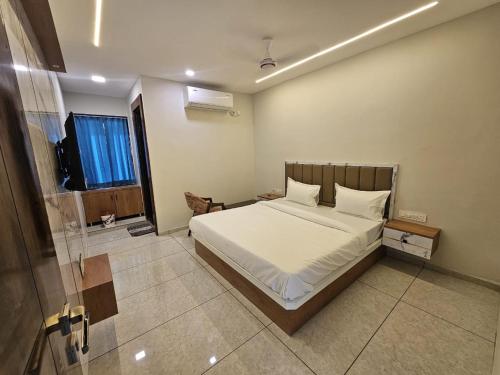 a bedroom with a white bed and a window at Hotel Shiv Inn in Himatnagar