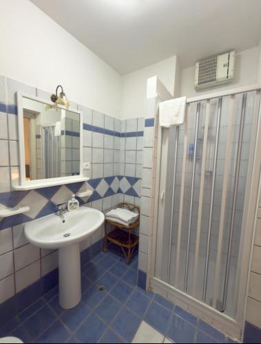 a blue and white bathroom with a sink and a shower at Marescià Siculiana Marina in Siculiana