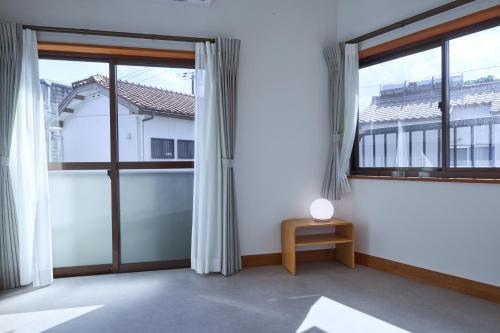 an empty room with large windows and a table at PinKumano by WhyKumano in Nachikatsuura