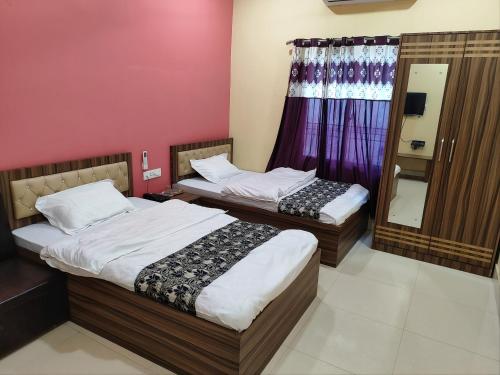 two twin beds in a room with a window at Bindwasini Hotel And Party Palace in Bīrganj