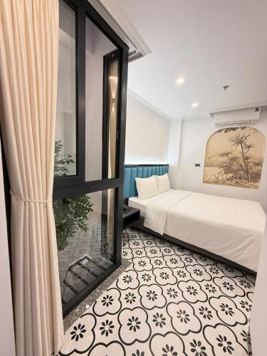 a bedroom with a bed and a large window at Hanoi Citadel Corner in Hanoi