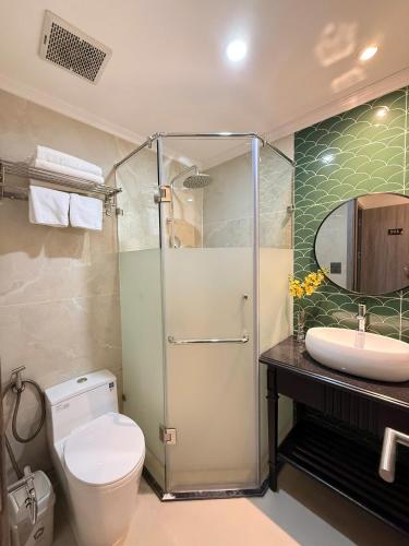 a bathroom with a shower and a toilet and a sink at Hanoi Citadel Corner in Hanoi