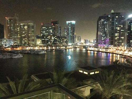 un profilo della città di notte con un fiume e edifici di My-Places Dubai Apartment suitable for large groups Al Sahab 1 a Dubai