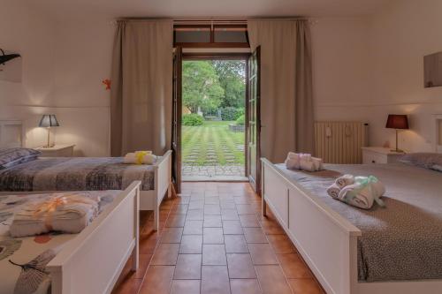 a bedroom with two beds and a door to a yard at Residenza Paradisea in Arezzo