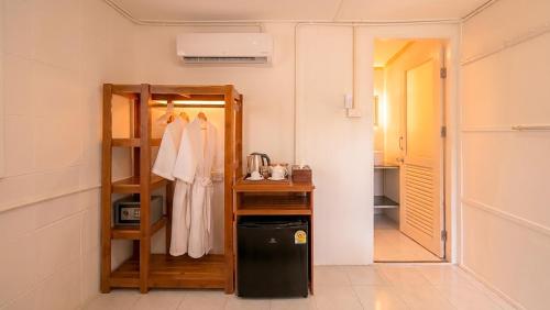 a room with a rack of clothes and a mirror at Le Panpurie Koh Lanta Resort - Near the Beach in Ko Lanta