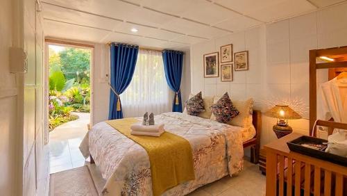 a bedroom with a bed with blue curtains and a window at Le Panpurie Koh Lanta Resort - Near the Beach in Ko Lanta