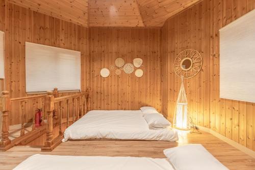 a bedroom with a bed in a wooden wall at 감성제주스테이 in Songnang-dong