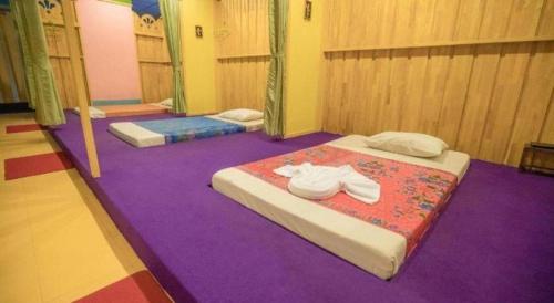 two beds in a room with purple carpet at Wangtai Hotel in Suratthani